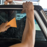 Technician Installing car window tint.